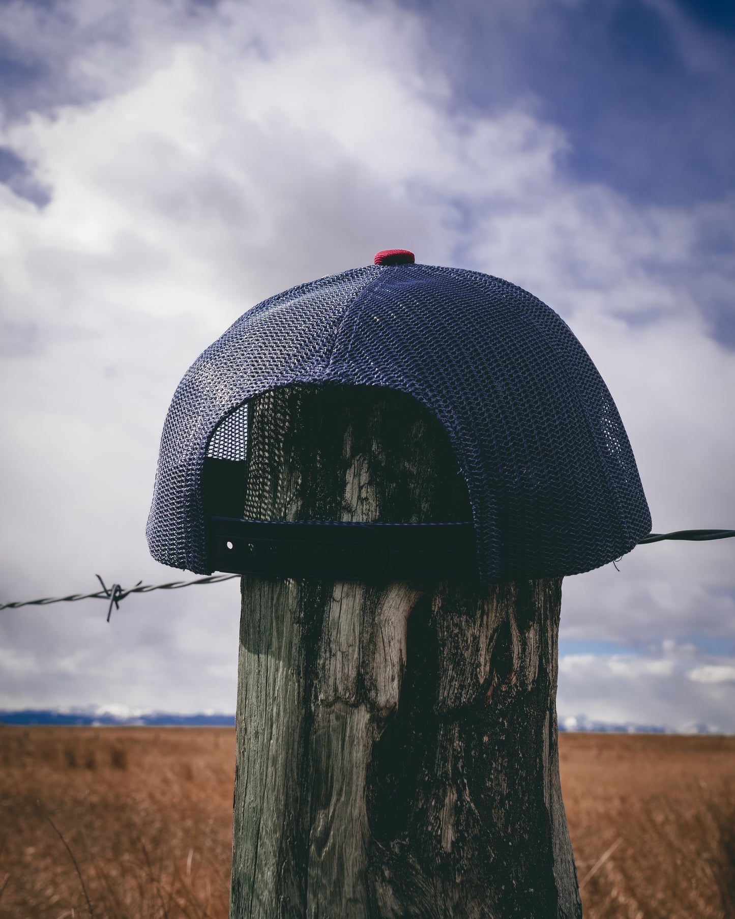 Out West ball cap in Burgundy-  Our in-demand trucker caps are finally here + proudly designed by Out West! Not only fun & functional but truly a stylish staple piece for any rancher!  A gorgeous burgundy color with a navy mesh back & adjustable strap.  A unique twist to this cap; the underside of the peak has a western-style pattern!