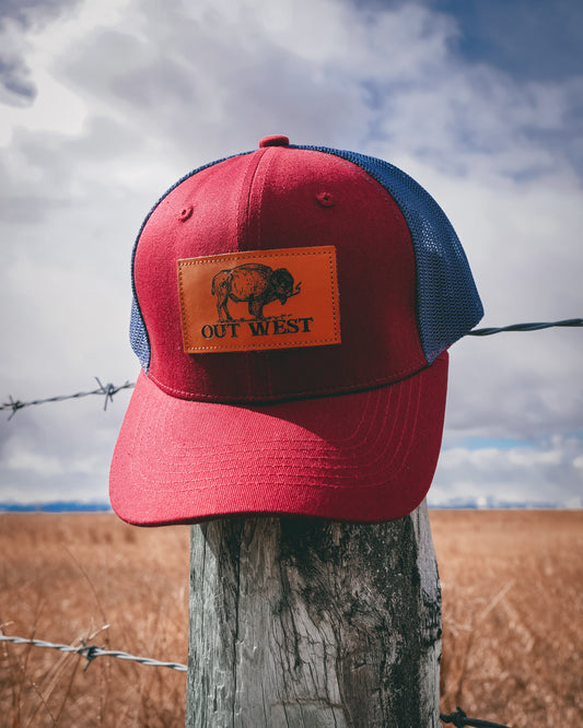 Out West ball cap in Burgundy-  Our in-demand trucker caps are finally here + proudly designed by Out West! Not only fun & functional but truly a stylish staple piece for any rancher!  A gorgeous burgundy color with a navy mesh back & adjustable strap.  A unique twist to this cap; the underside of the peak has a western-style pattern!