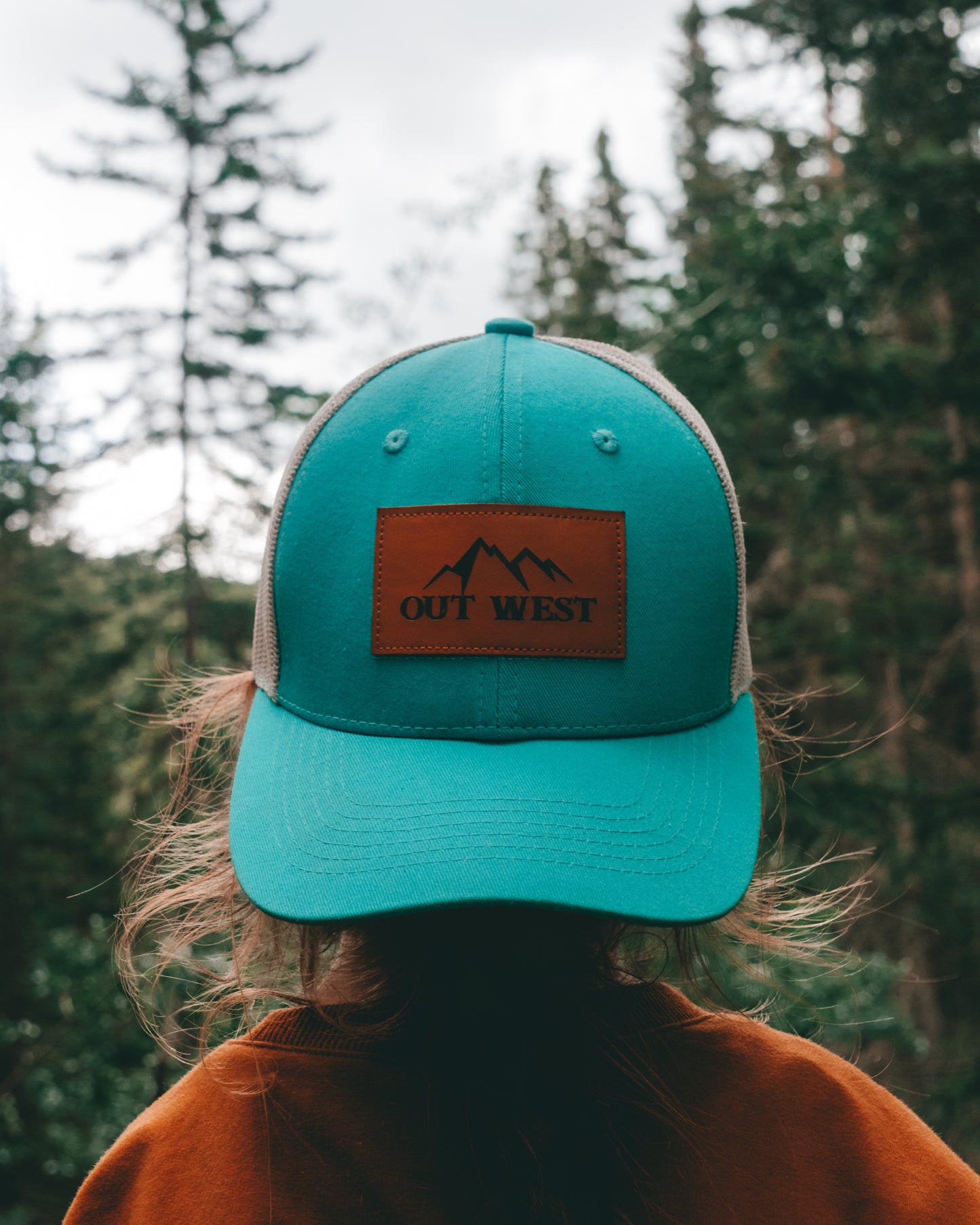 Out West ball cap in Aqua-  Our in-demand trucker caps are finally here + proudly designed by Out West! Not only fun & functional but truly a stylish staple piece for any rancher!  A gorgeous aqua color with a light cream mesh back & adjustable strap.