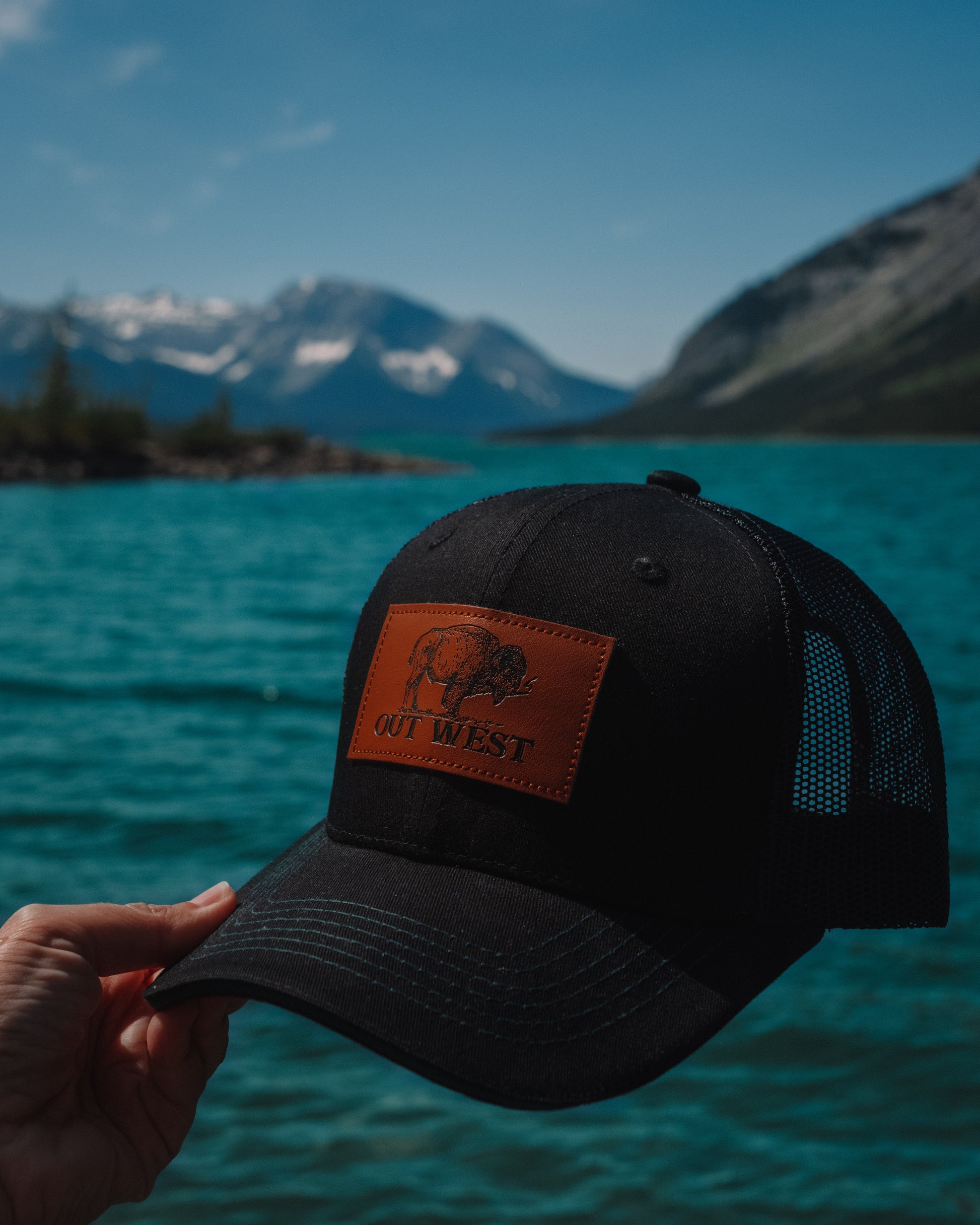 Out West ball cap in Black-  Our in-demand trucker caps are finally here + proudly designed by Out West! Not only fun & functional but truly a stylish staple piece for any rancher!  Black with black mesh back & adjustable strap. The underside of the peak is burgundy with a dark green trim.